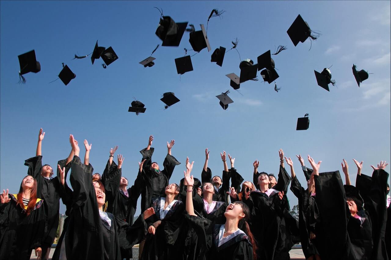 Image of graduates throwing their hats in the air