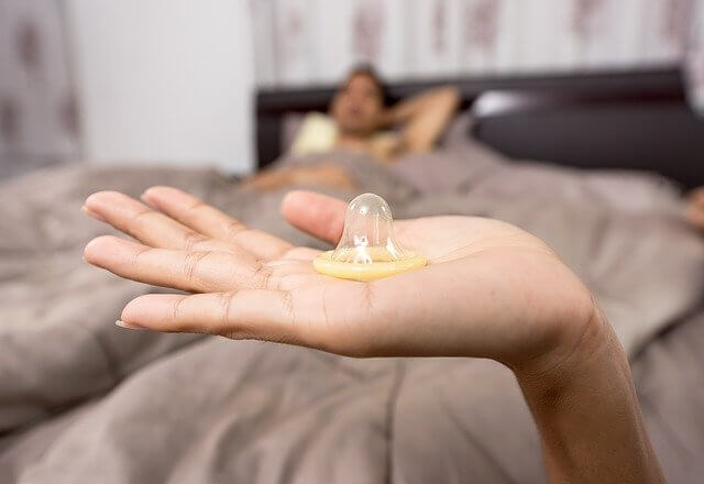 Image of a girl holding a condom