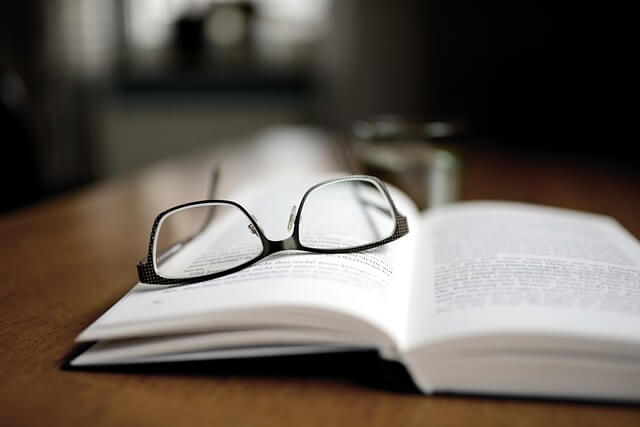 A pair of glasses on top of an opened book